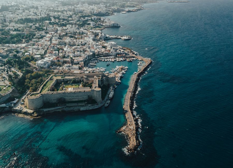 A stunning aerial shot showcasing a coastal city with a prominent fort and marina.