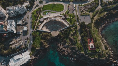 Free A striking aerial view of an amphitheater by the coast with urban surroundings. Stock Photo