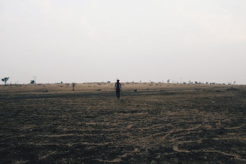 Person Walking on Brown Soil 