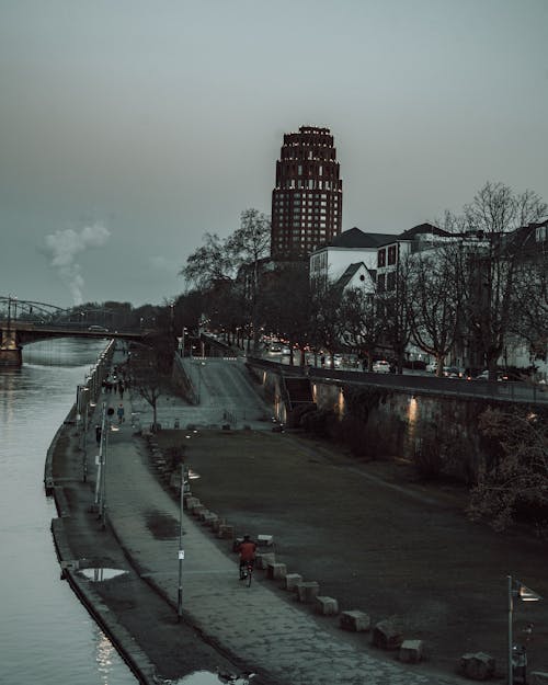 Free White Concrete Building near River under Gloomy Sky Stock Photo