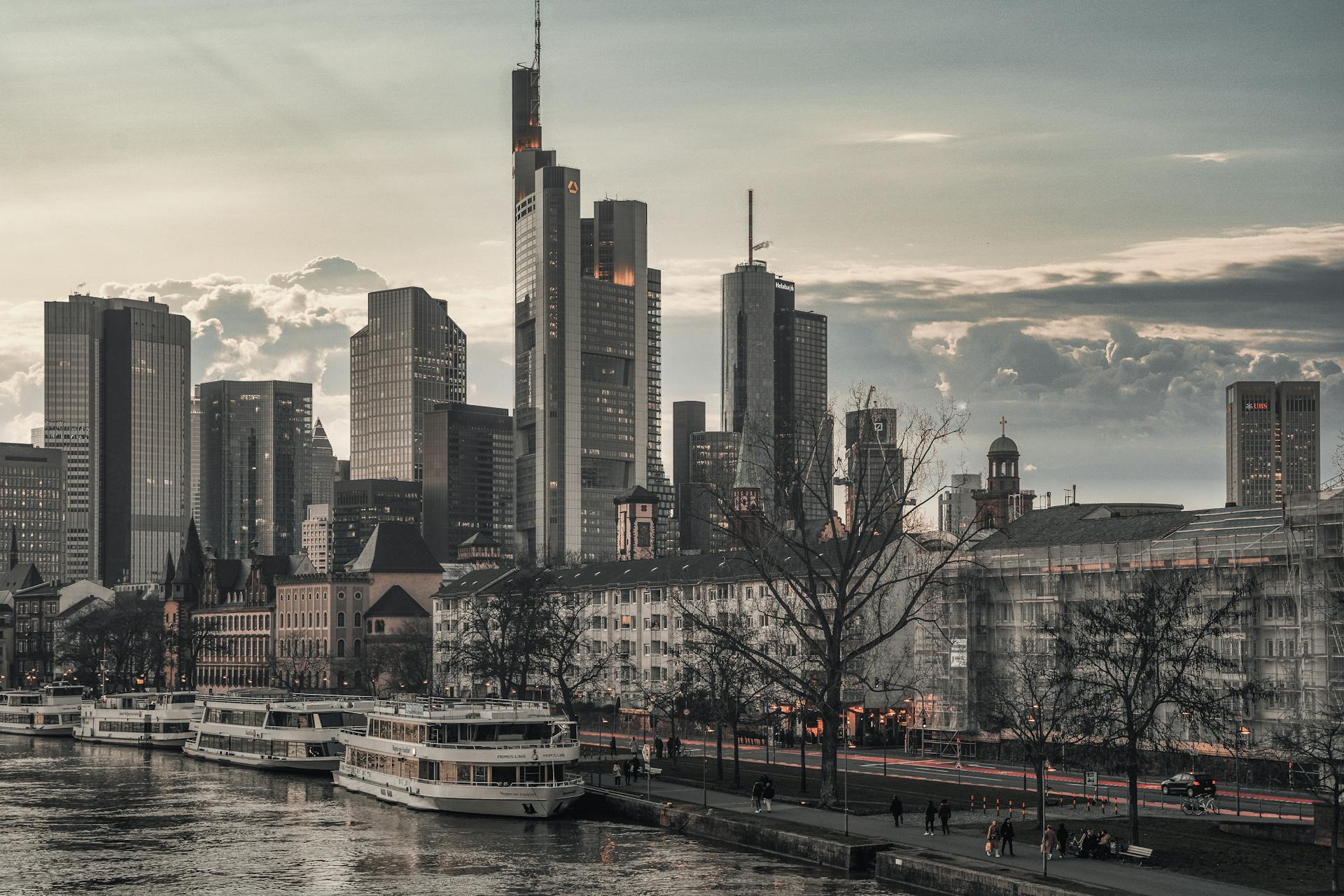 View of Frankfurt's skyline featuring the Commerzbank Tower and river with boats.