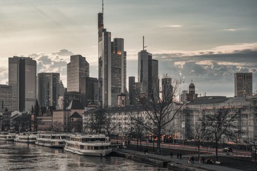 Free View of Frankfurt's skyline featuring the Commerzbank Tower and river with boats. Stock Photo