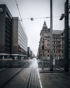 Perspective view of a city street featuring historic and modern architecture on a cloudy day.
