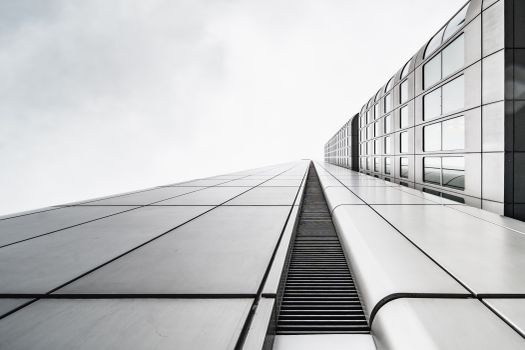 A stunning black and white close-up view of a modern skyscraper extending into the sky.