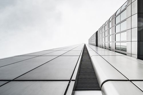Free A stunning black and white close-up view of a modern skyscraper extending into the sky. Stock Photo