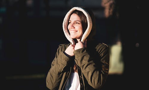 Free Smiling Woman Holding Her Hoodie Stock Photo