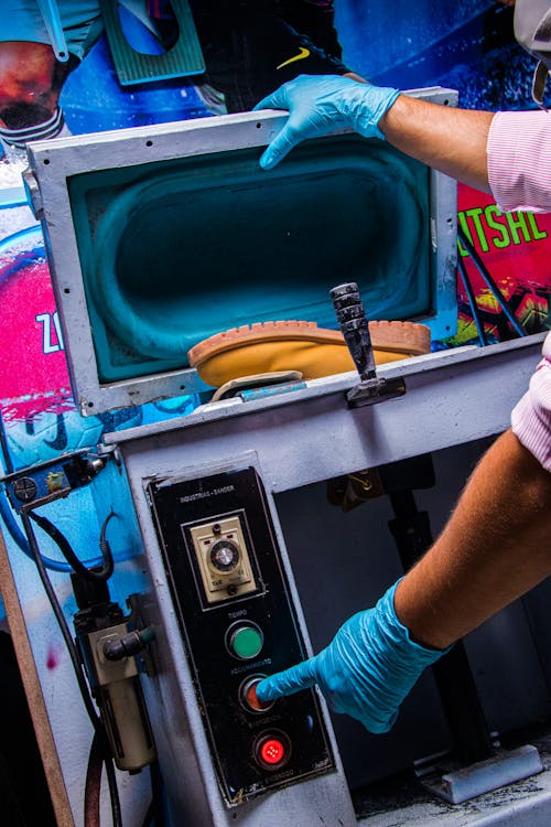 Free A Person Wearing Latex Gloves Pressing the Button of the Machine Stock Photo