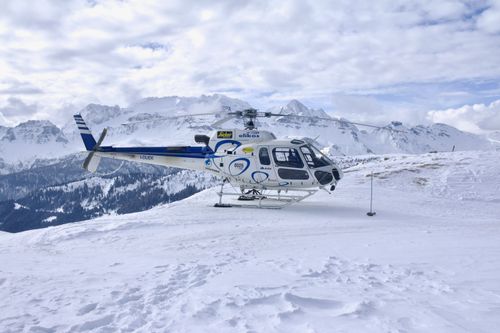 Free A helicopter on snowy alpine mountains in Corvara, showcasing winter's majesty. Stock Photo
