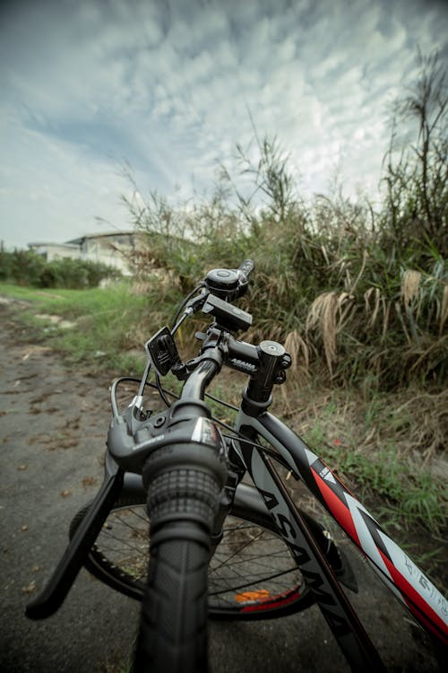 Photos gratuites de bicyclette, chemin de terre, ciel nuageux