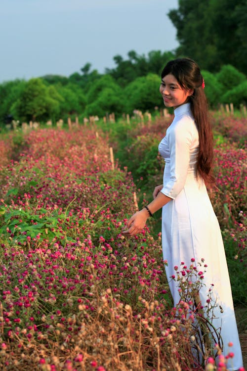 Free Woman in White Dress Standing in Flower Field Stock Photo