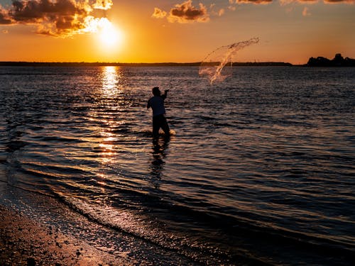 Silhouette of Man Throwing a Fishing Net