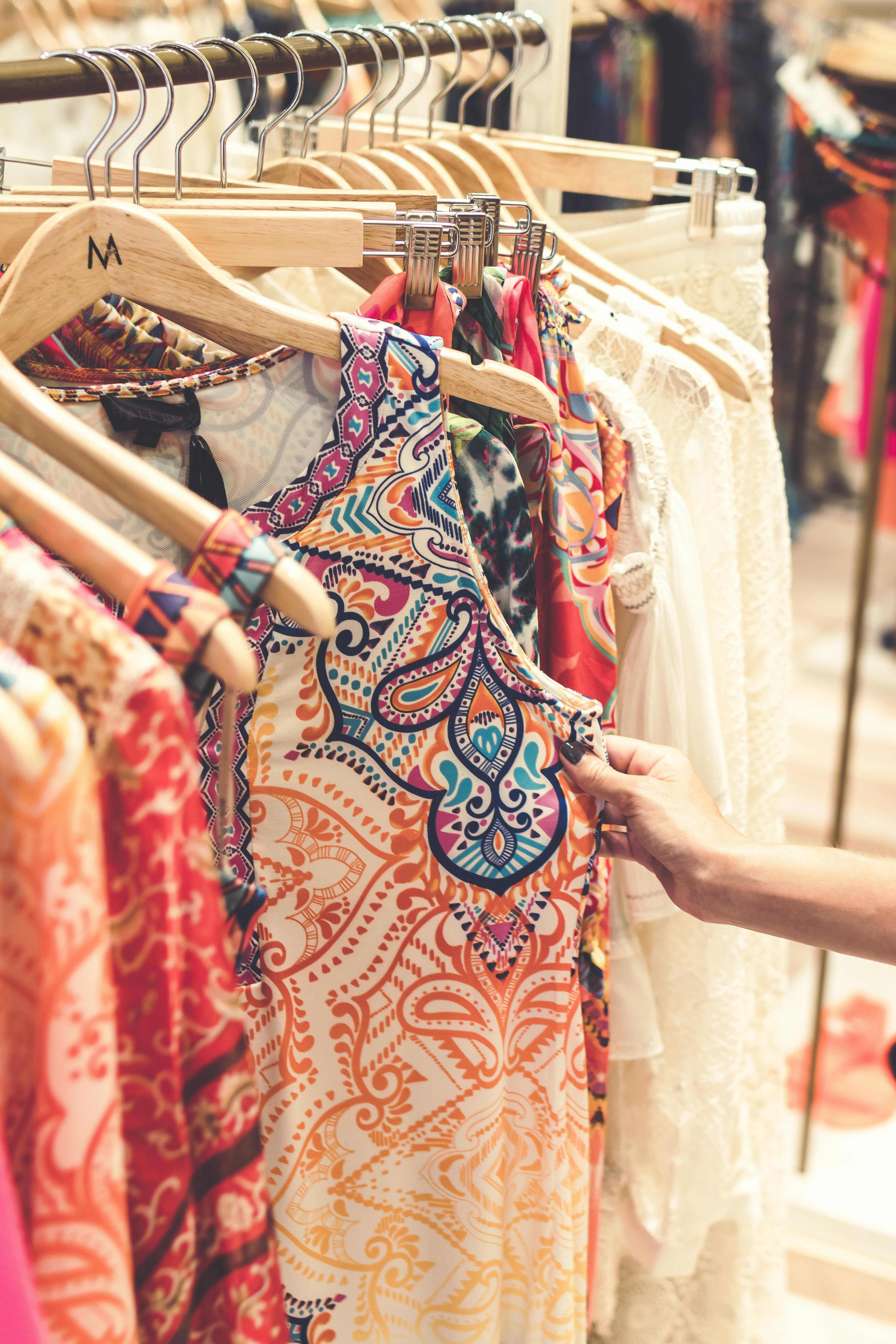 shallow focus photography of assorted color clothes hanged on clothes rack