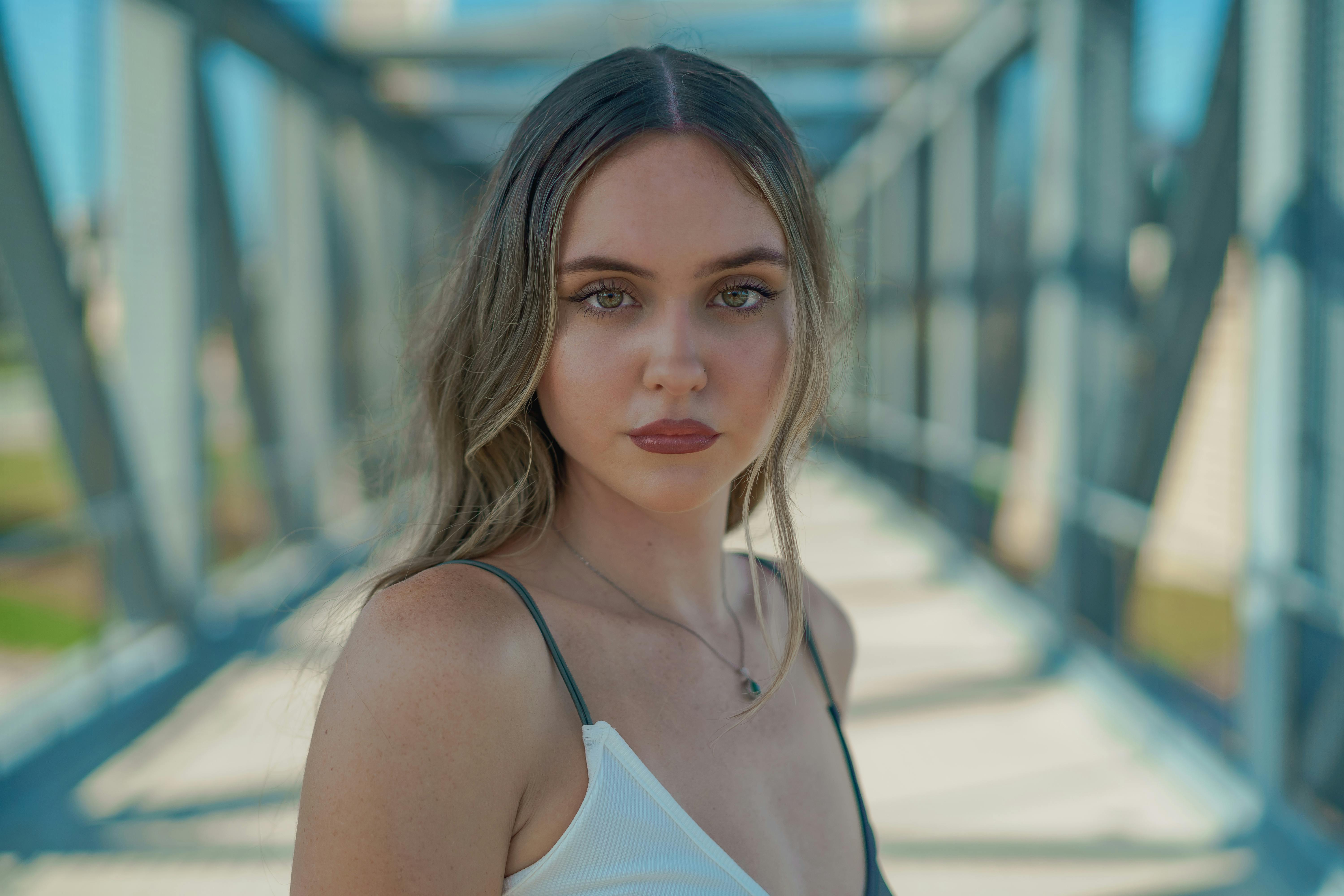 Elegant portrait of a young woman standing on a modern bridge in Orlando, Florida.