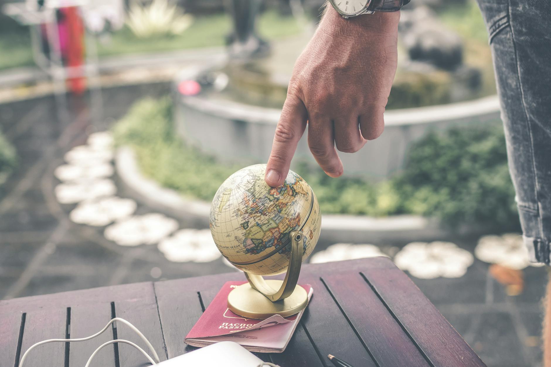 man touching miniature globe