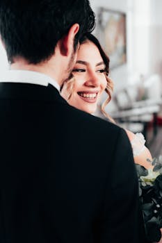 A joyful bride and groom sharing a moment indoors on their wedding day.
