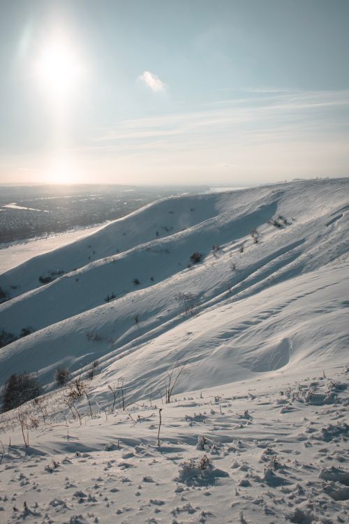 Free A serene snow-covered mountain landscape under soft winter sunlight, ideal for nature-themed projects. Stock Photo