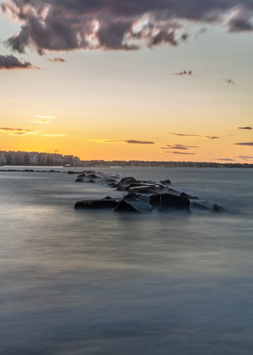 Big Rocks on Body of Water During Golden Hour 