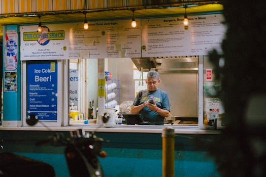 A street vendor in Key West, Florida serves customers at a food stand during the night.