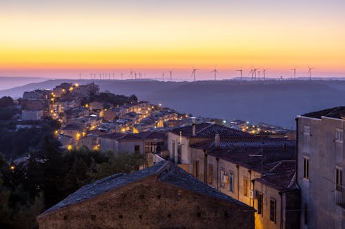 High Angle View of Town at Dusk with Wind Turbines in the Distance