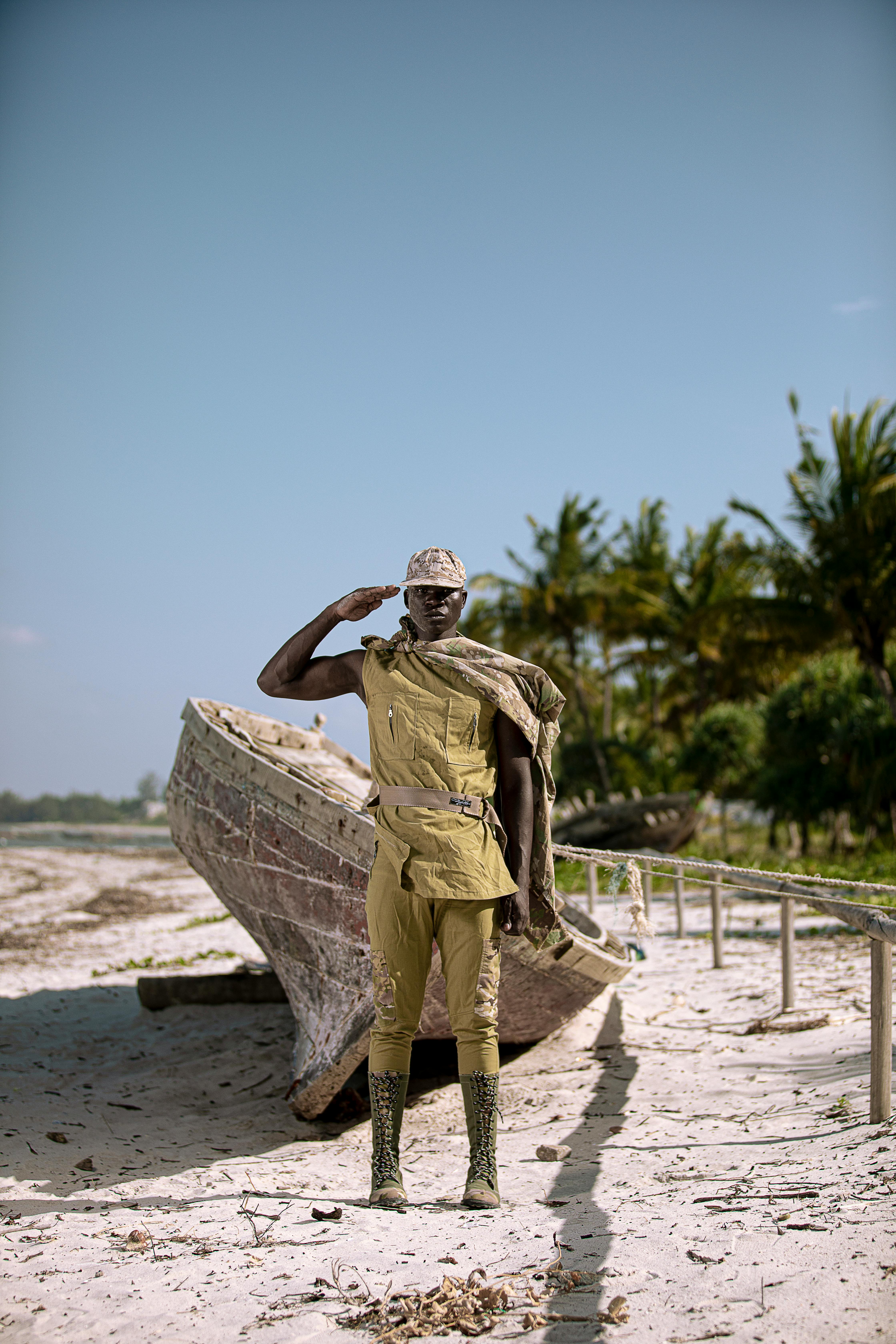 soldier saluting while standing on beach