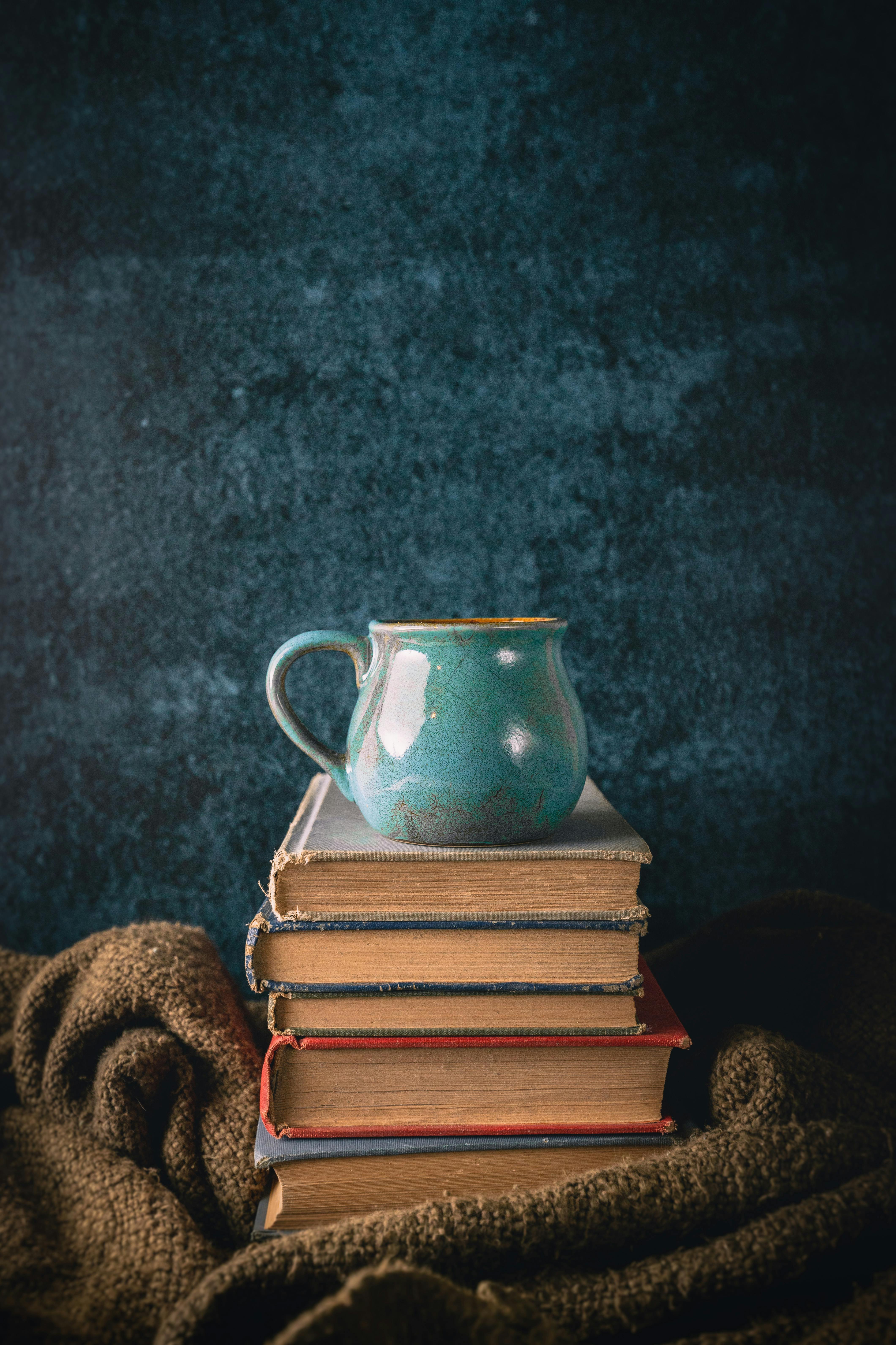 cup on books on blanket