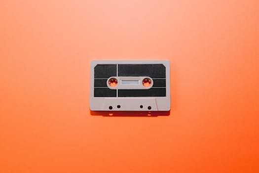A retro cassette tape placed on a vibrant orange backdrop, evoking nostalgia.