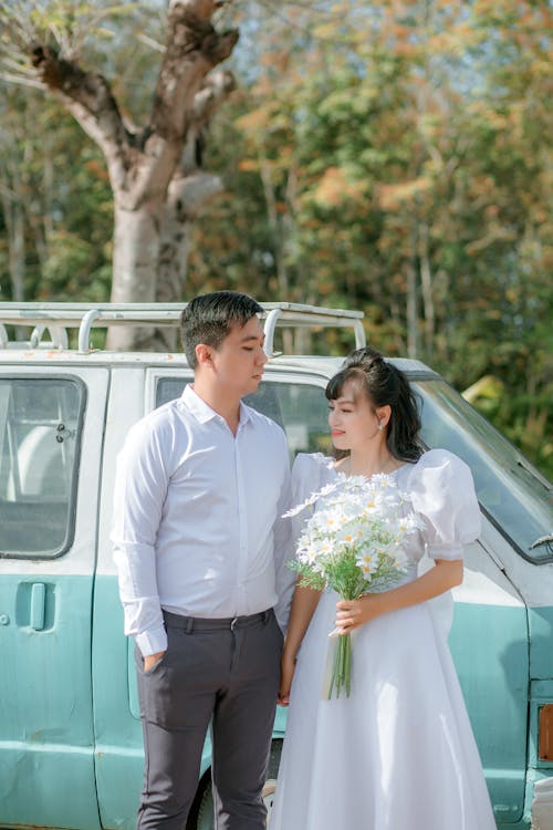 Free Bride and Groom Standing Beside a Van  Stock Photo