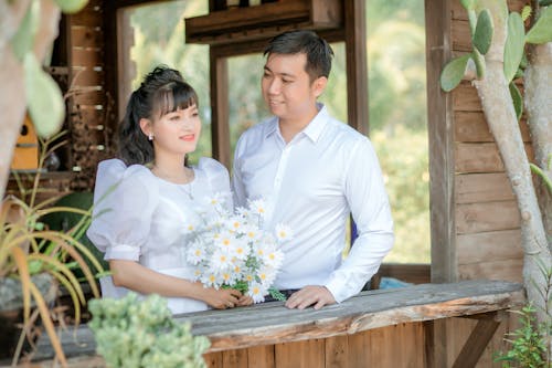 Man in White Dress Shirt Looking at Woman in White Dress