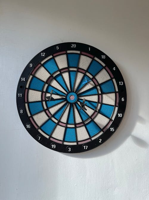 Dartboard with Darts in it on the White Wall 