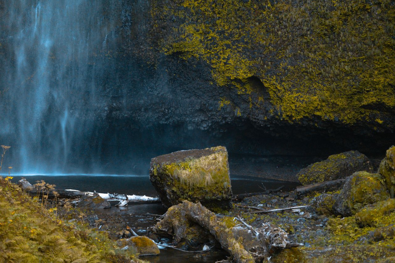 serene waterfall cascading over moss covered rocks in a tranquil outdo