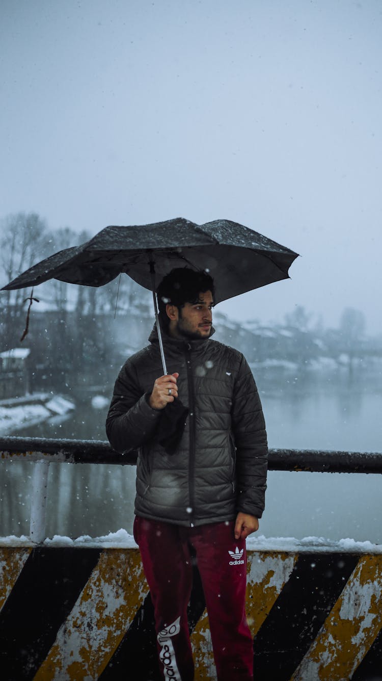 Man In Black Puffer Jacket Holding Umbrella