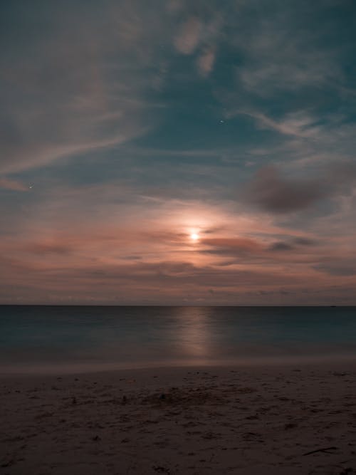 Body of Water Under Cloudy Sky during Sunset