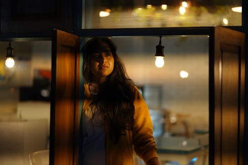 Woman Standing Beside Window Shutters