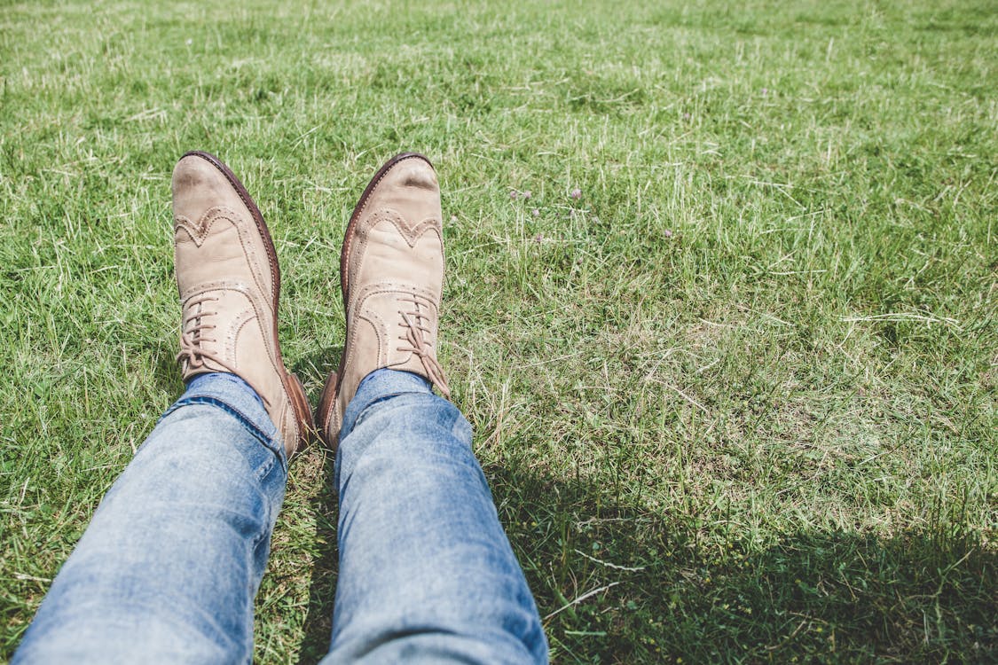 무료 잔디에 앉아 블루 데님 청바지를 입고 사람 스톡 사진