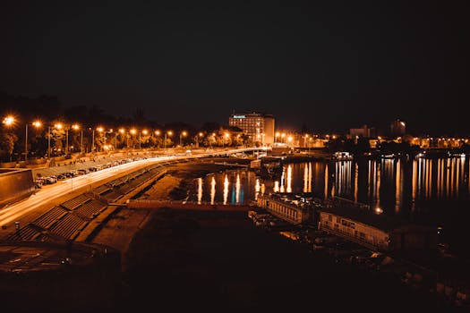 Stunning aerial view of Szeged at night showcasing illuminated streets and reflections on the waterfront.