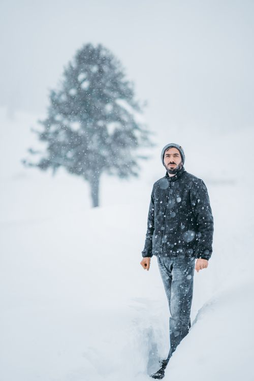 Free A man in winter attire standing in a snow-covered landscape in Gulmarg. Stock Photo