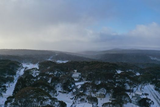 Discover the serene winter beauty of Hotham Heights from above, showcasing snowy landscapes and tranquil forests.