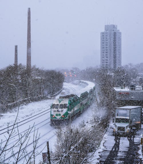 Green and Black Train on Snow Covered Train Track