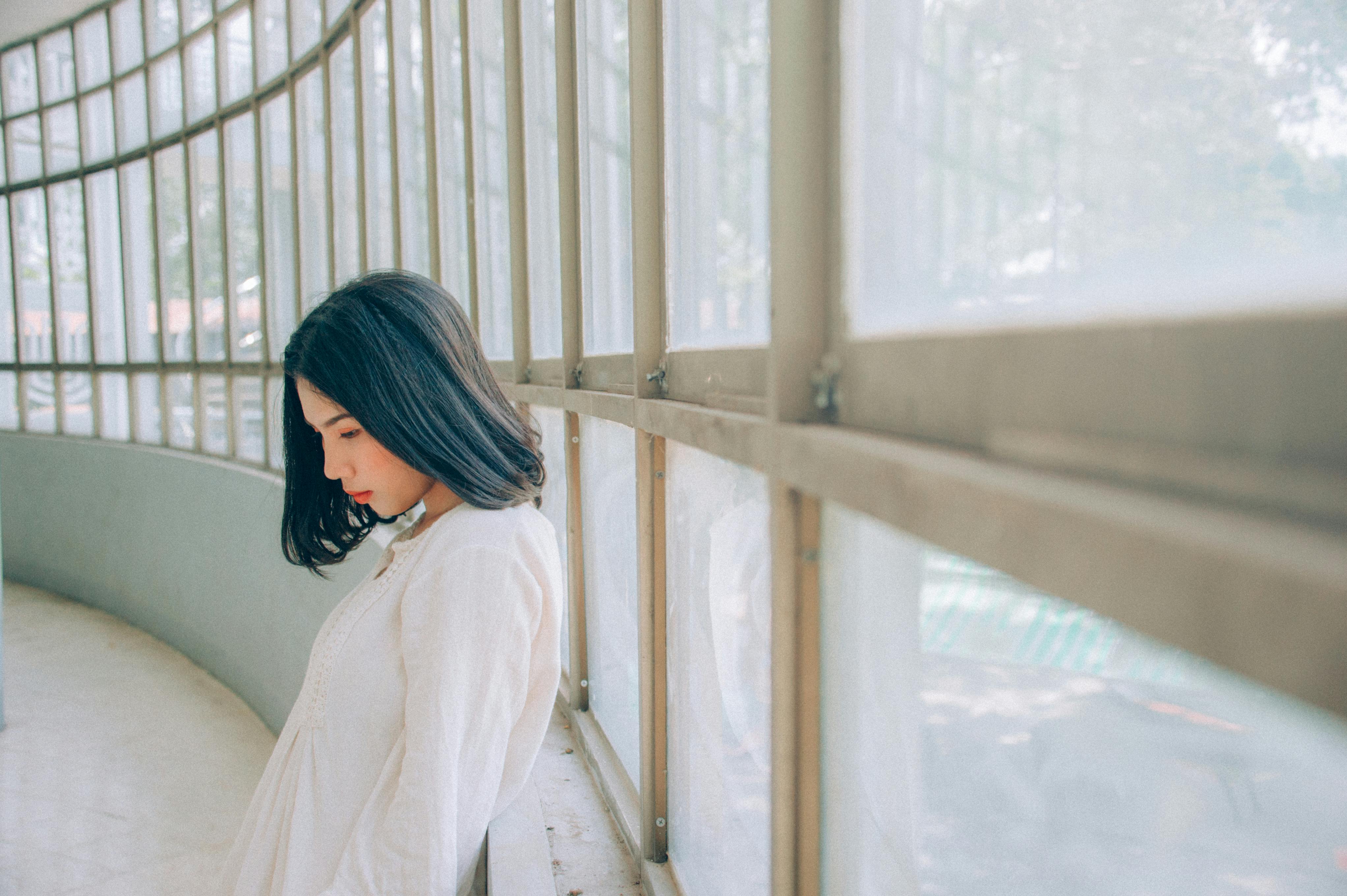 Woman Wearing White Top Beside Window at Daytime · Free Stock Photo