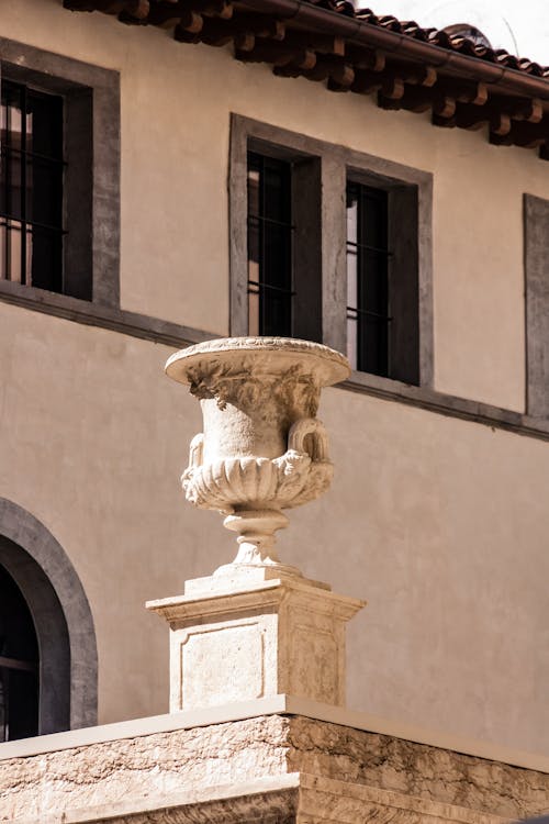Close-up of an Ancient Vase Sculpture on the Background of a Building 