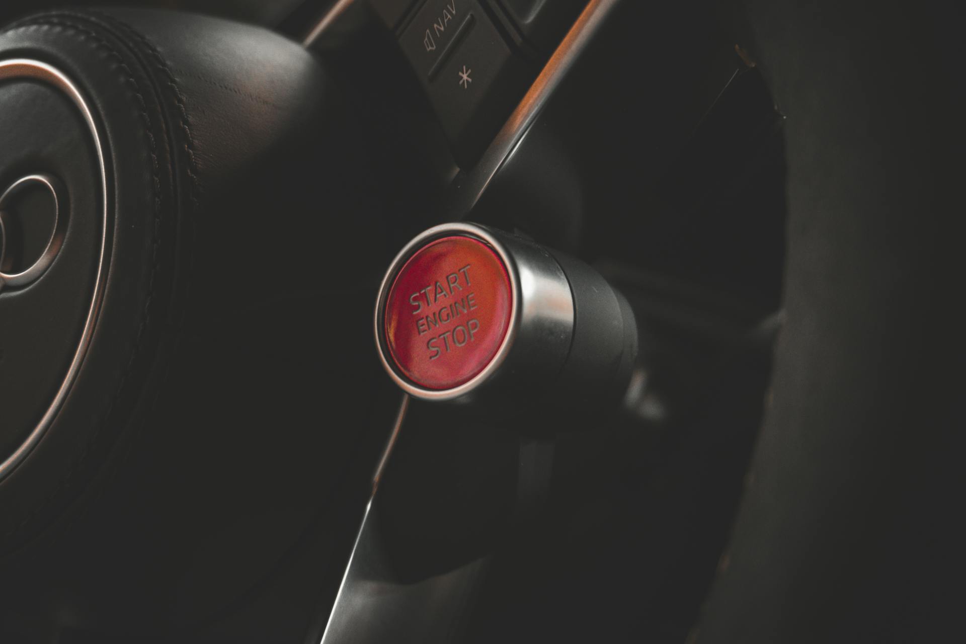 Close-up of a red start engine stop button inside a car, highlighting modern vehicle technology.