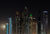 迪拜明亮的摩天大楼在夜空中展现出令人惊叹的景色，捕捉了城市的建筑风貌