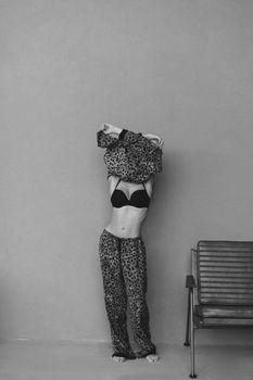 Artistic black and white photo of a woman in a leopard print outfit indoors.