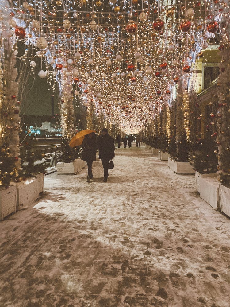 People Walking Winter Street With Lights Decoration