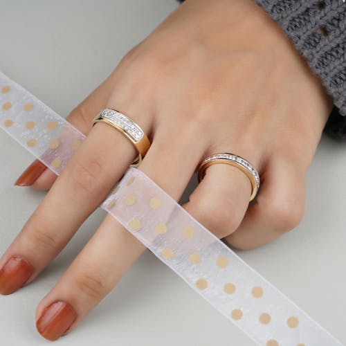 Person Wearing Gold Rings with Diamonds 