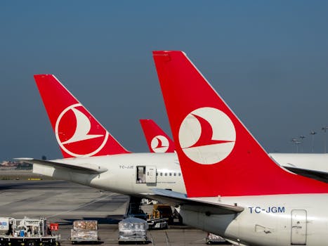 Red-tailed Turkish Airlines planes on the tarmac at Istanbul Airport, showcasing travel and aviation.