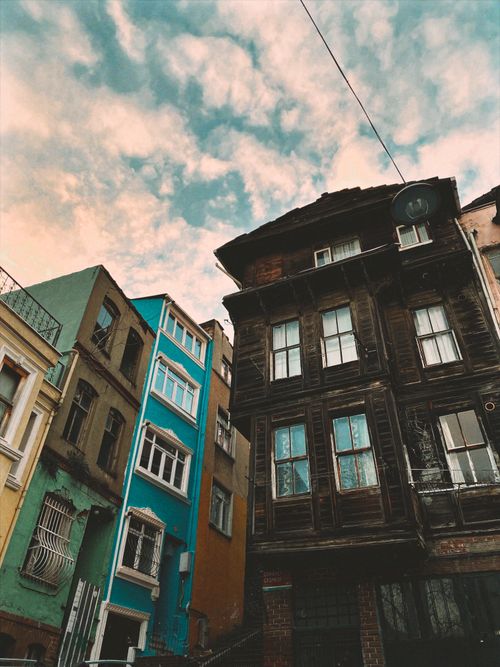 Free Low angle shot of diverse urban buildings with vibrant facades under a cloudy sky. Stock Photo