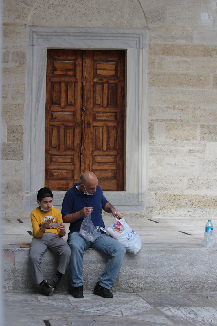 Father And Son Sitting Outdoors