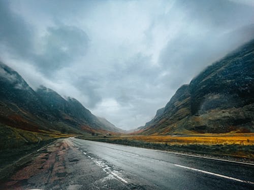 A road in the scottish highlands with mountains in the background