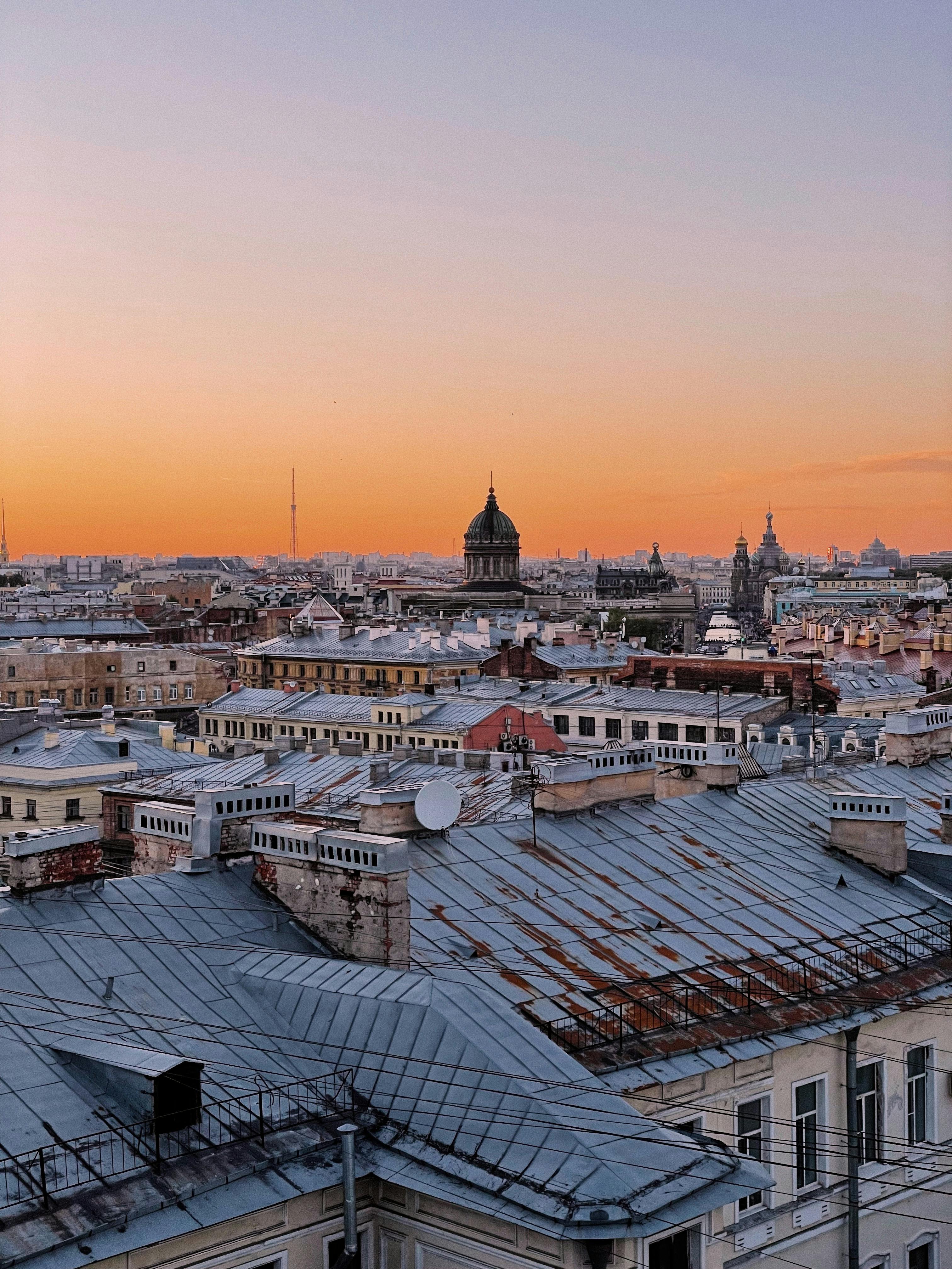 Capturing the scenic rooftops of St. Petersburg at sunset with a warm sky.